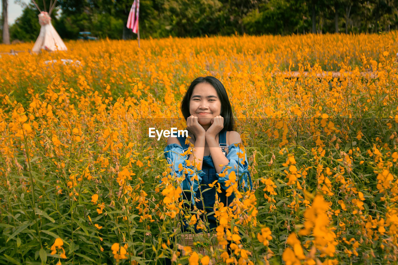 A cheerful girl in a yellow flower field