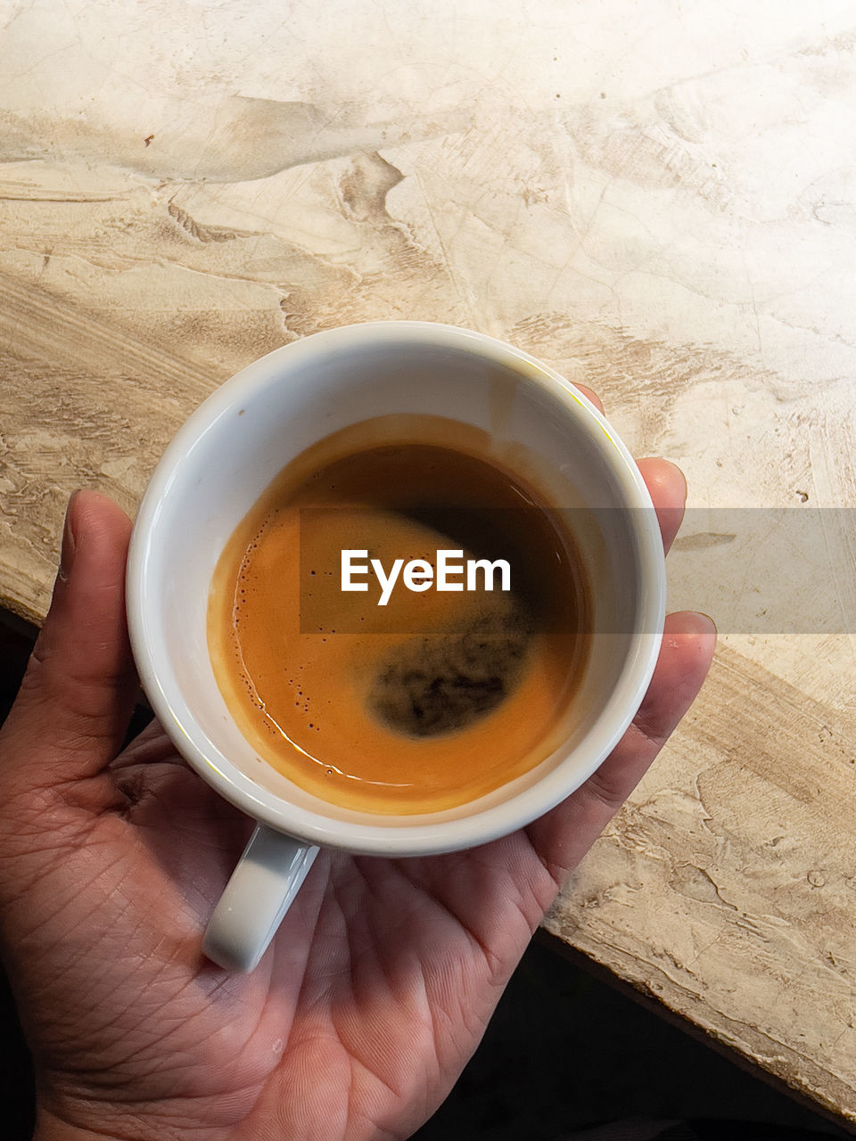 HIGH ANGLE VIEW OF PERSON HOLDING TEA CUP