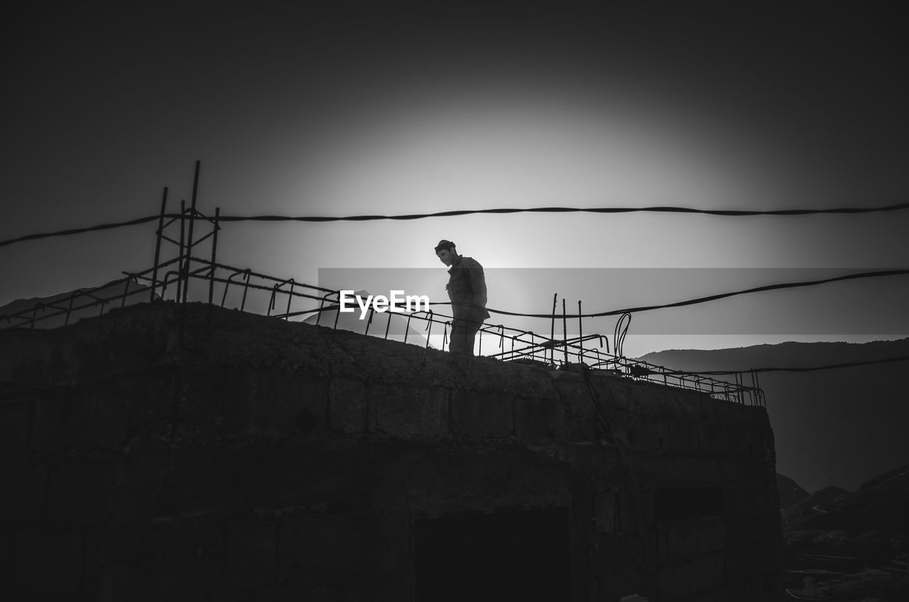 SILHOUETTE MAN STANDING AGAINST CLEAR SKY