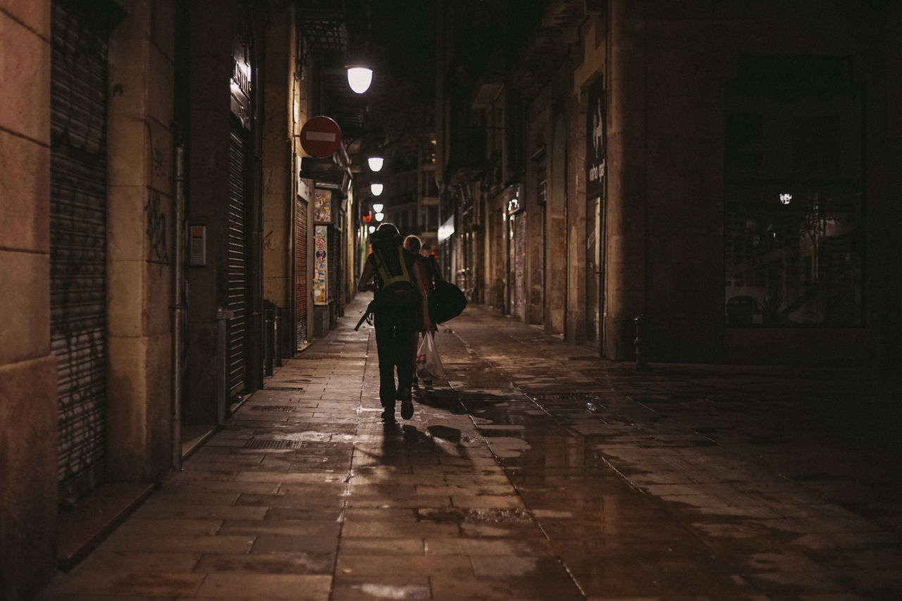 Women walking on street amidst buildings at night