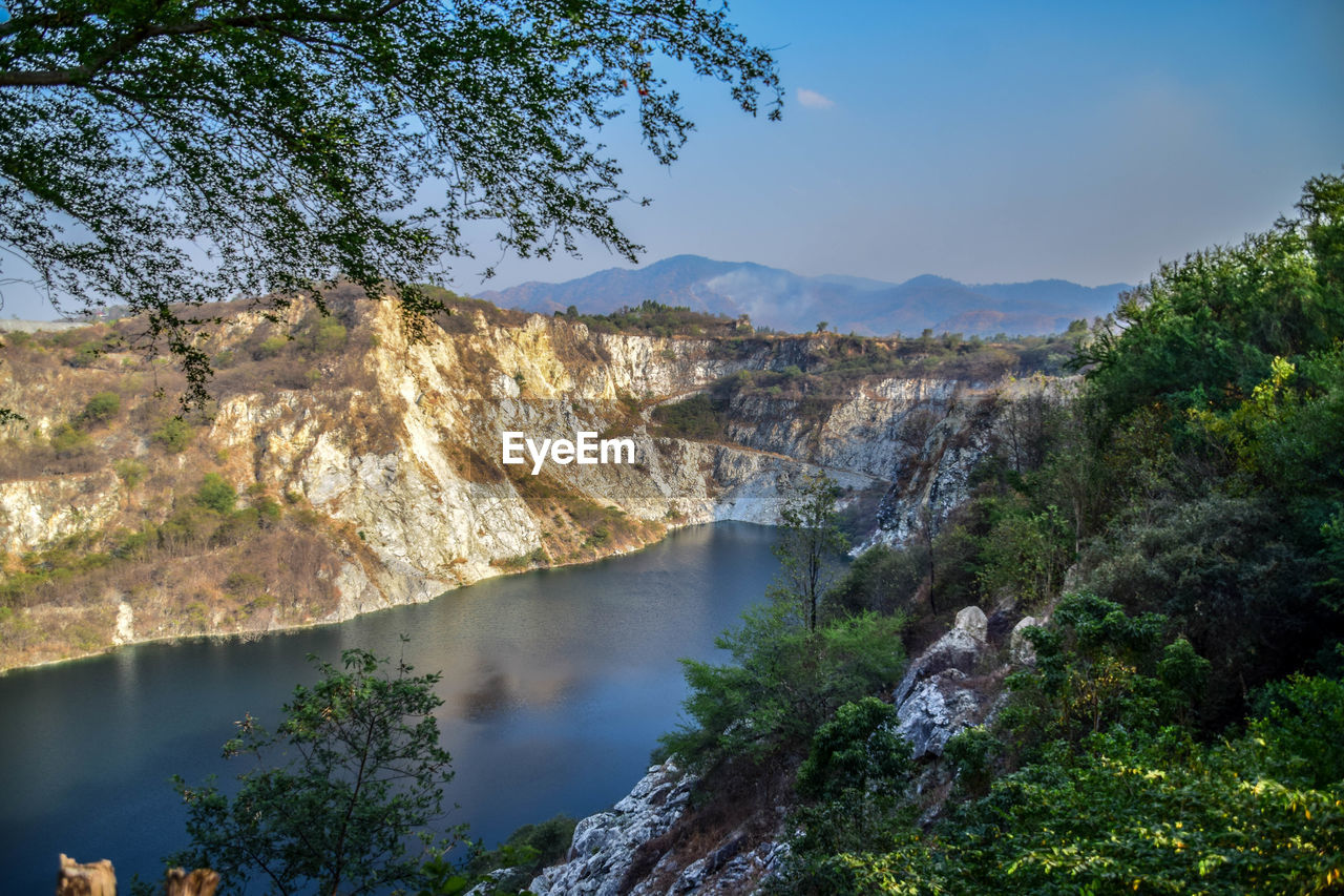 Scenic view of river amidst trees against sky