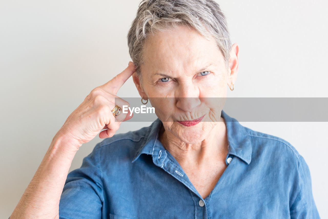 Portrait of woman gesturing against white background