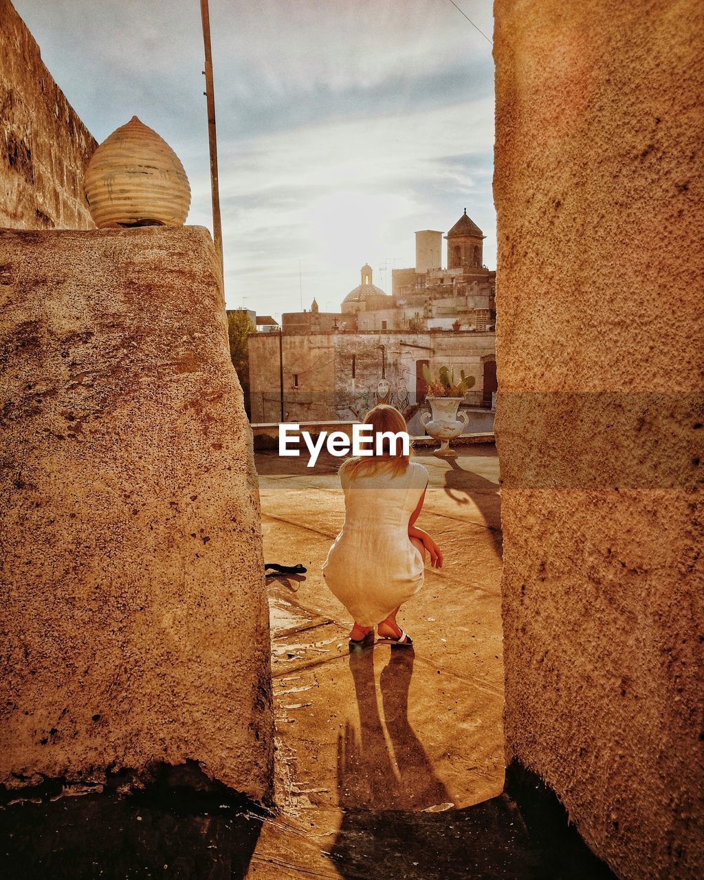 Rear view of woman looking at buildings against sky