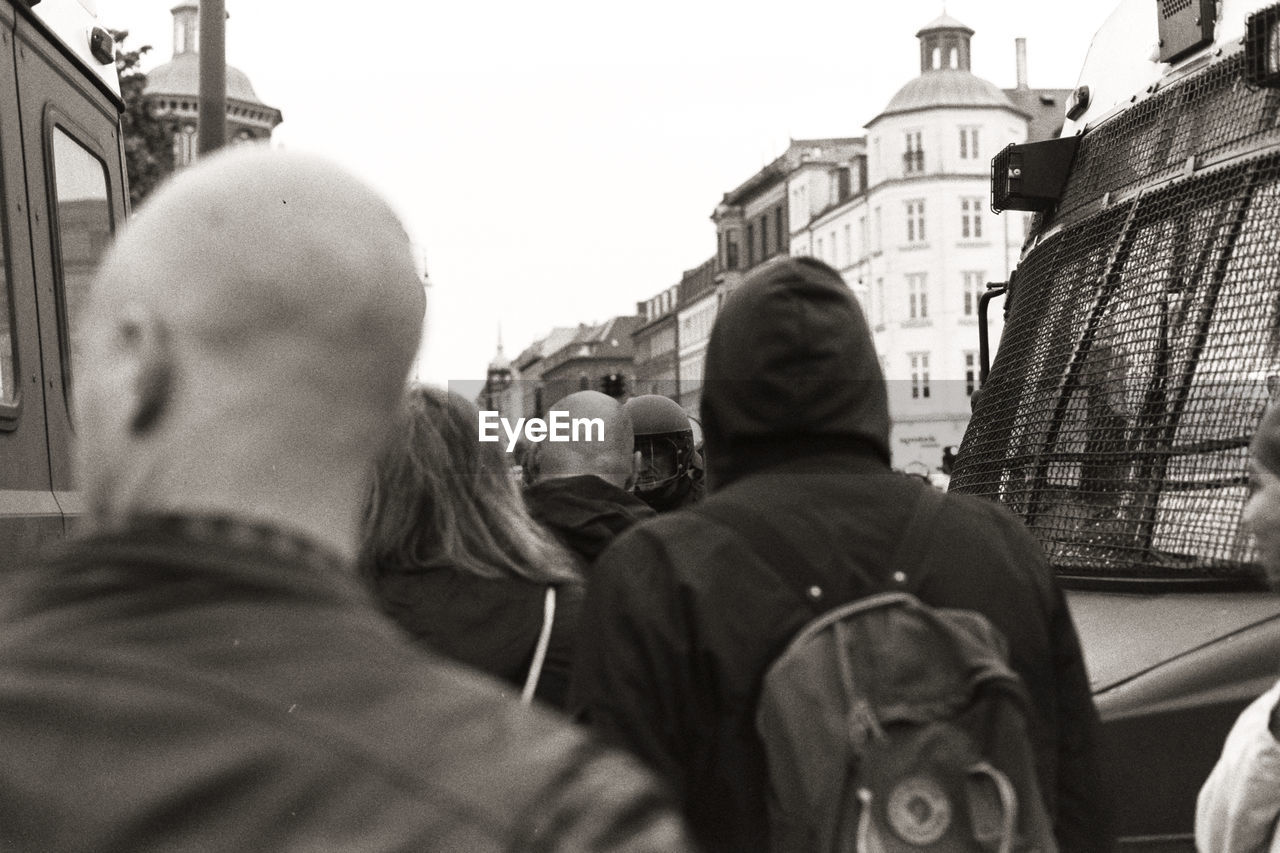 REAR VIEW OF PEOPLE IN FRONT OF BUILDING