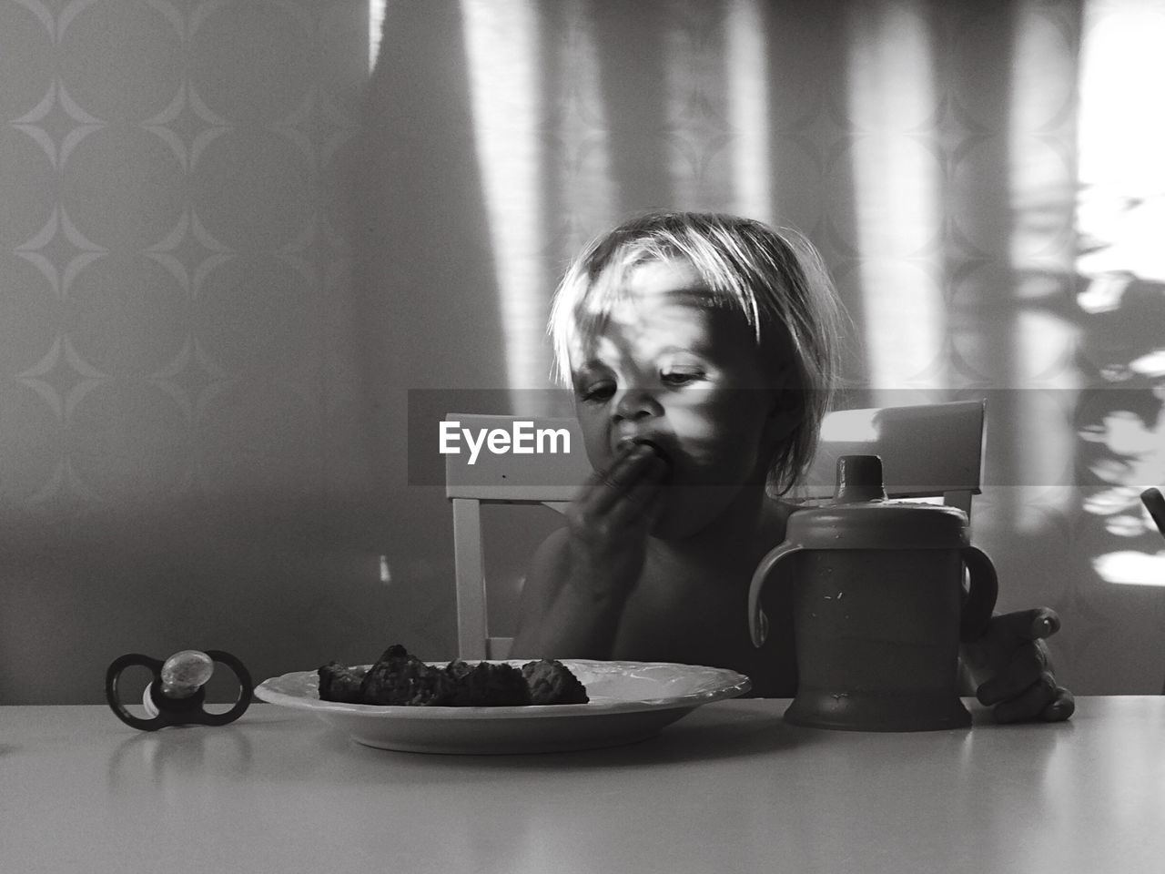 Toddler having food while sitting at table