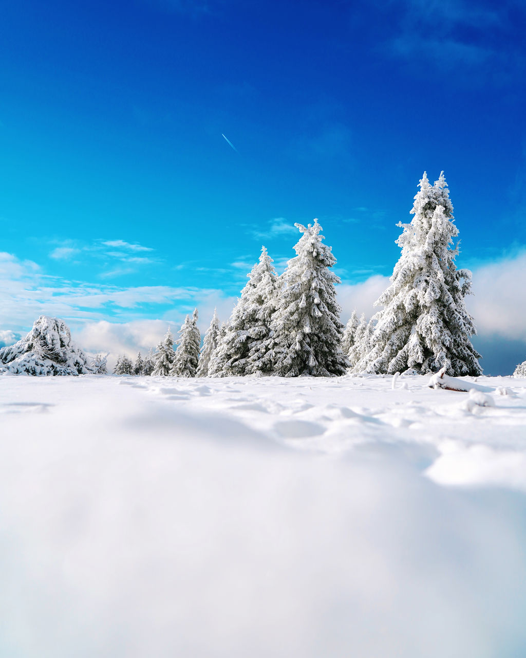 SURFACE LEVEL OF SNOW COVERED MOUNTAIN AGAINST BLUE SKY