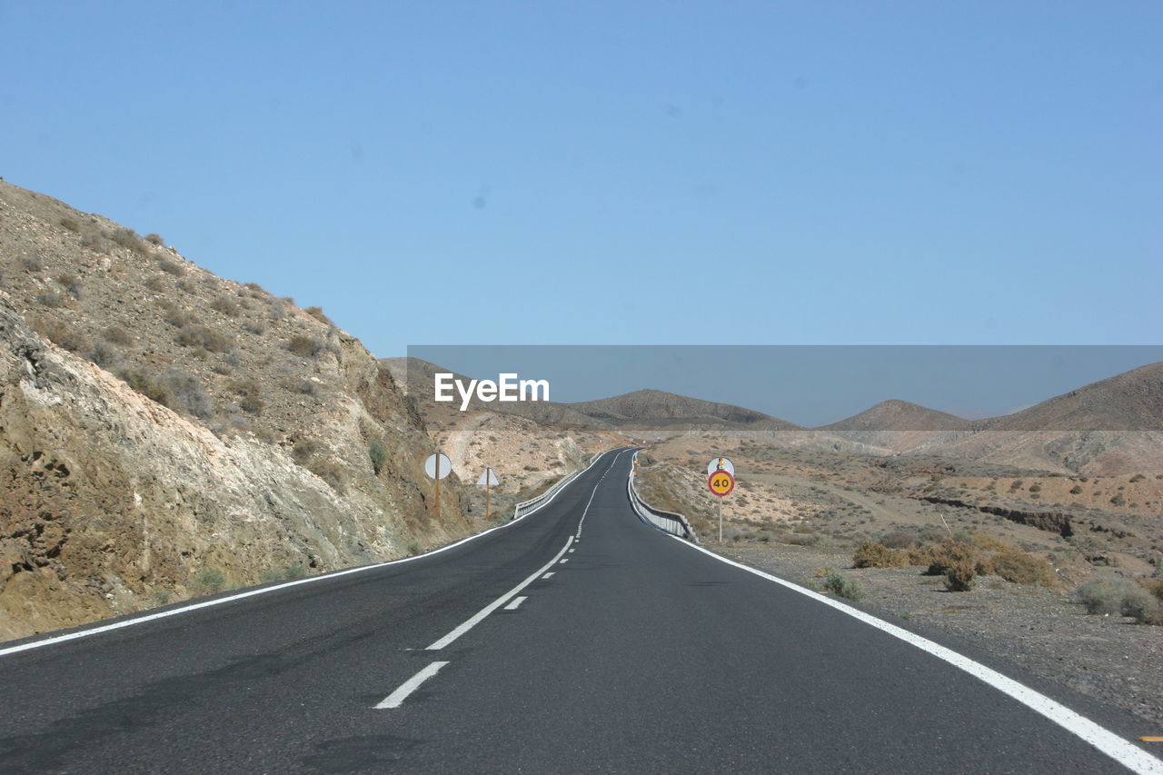 Empty road by mountain against sky