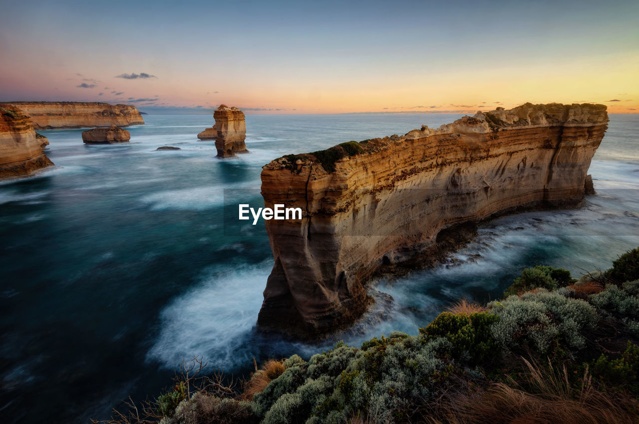 ROCK FORMATIONS ON SEA SHORE AGAINST SKY