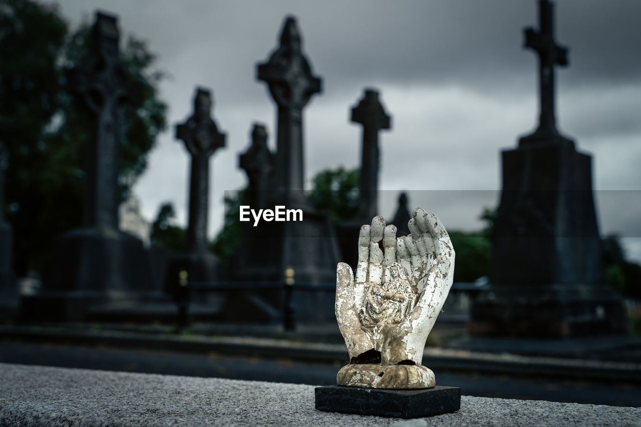 Sculpture of hands holding holly mary and jesus christ, glasnevin cemetery, ireland