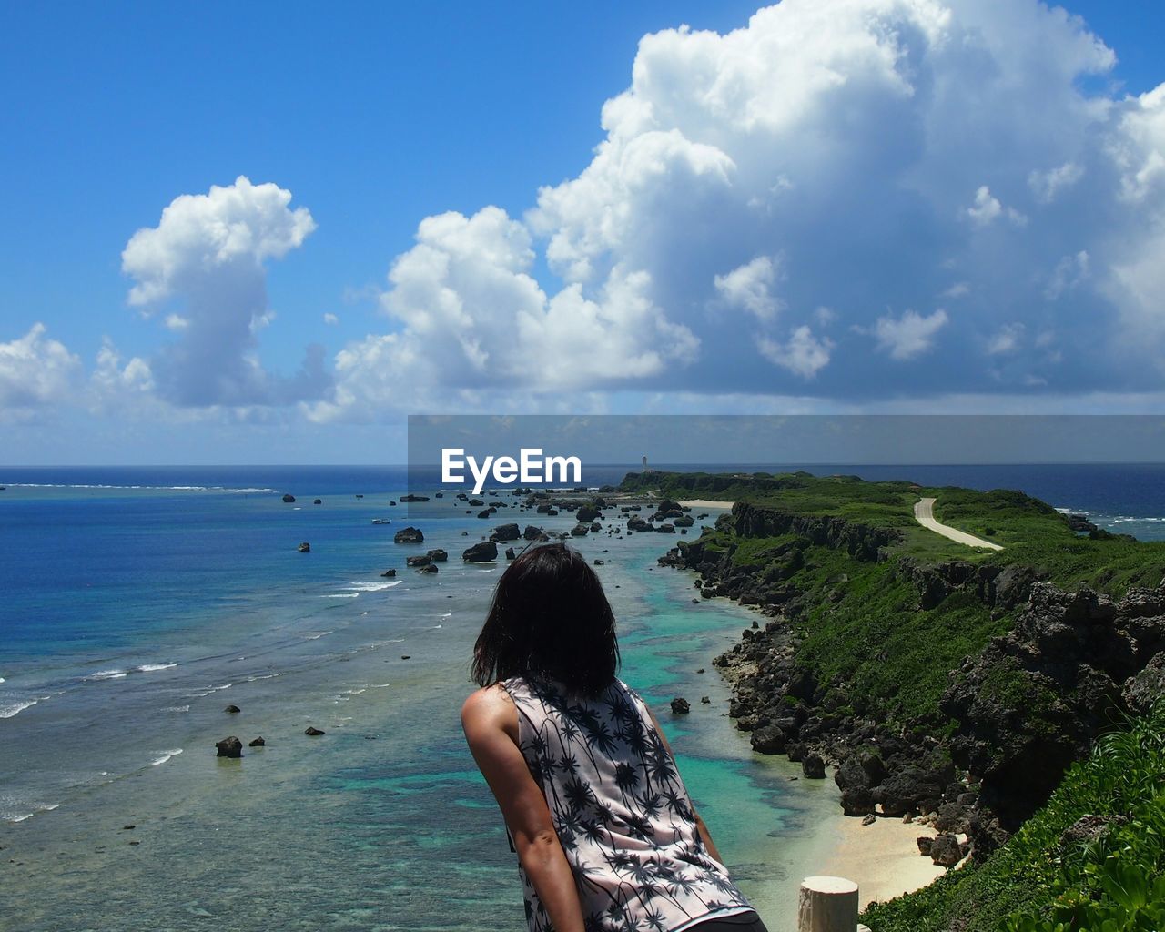 Rear view of woman standing against sea