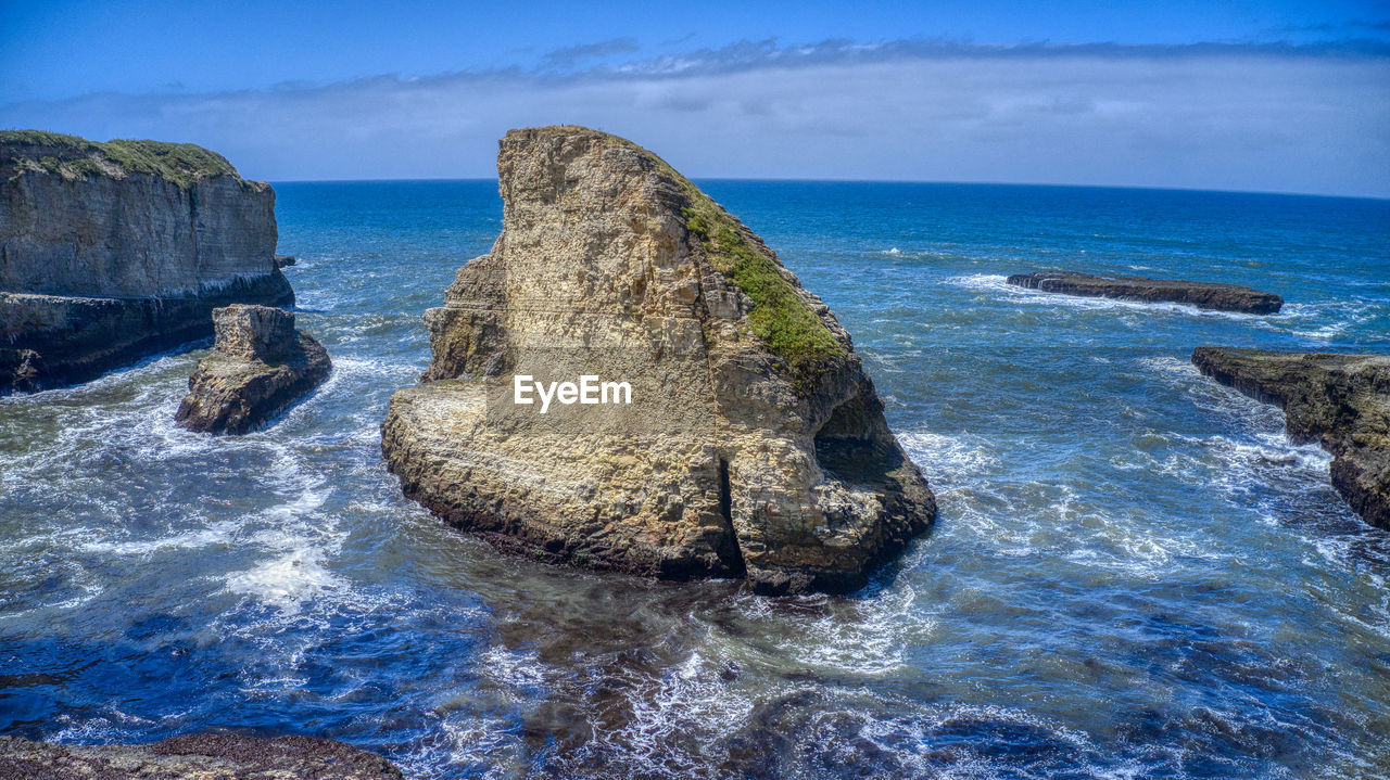 Rock formation on sea against sky