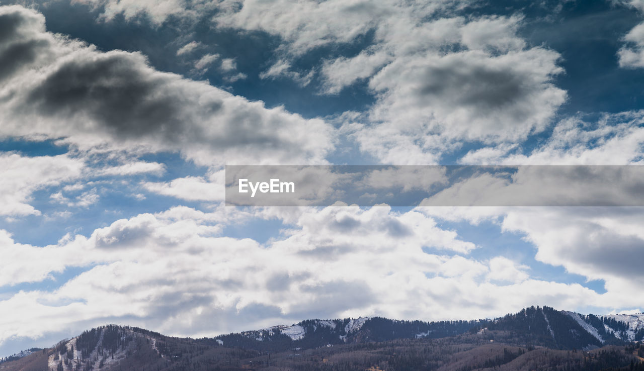 LOW ANGLE VIEW OF CLOUDS OVER MOUNTAIN