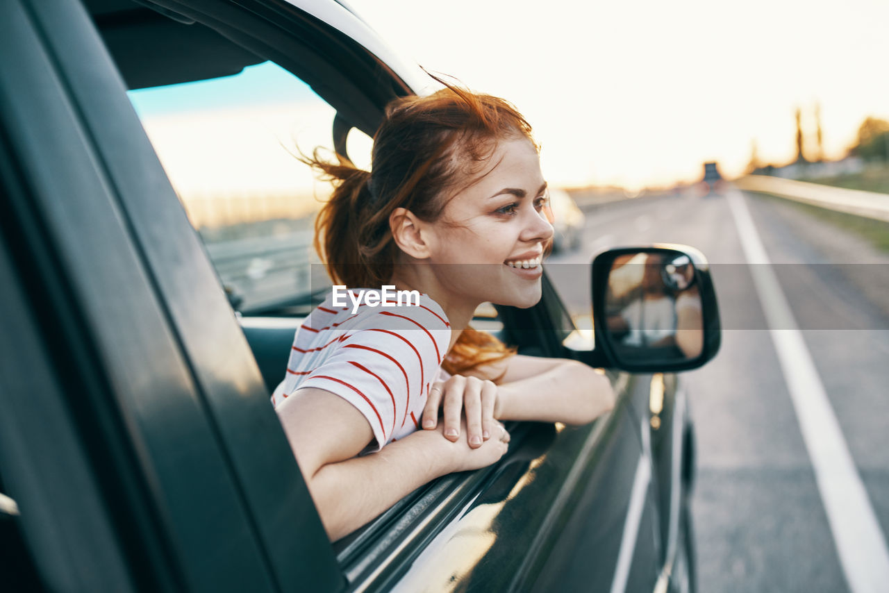 Portrait of happy woman sitting in car