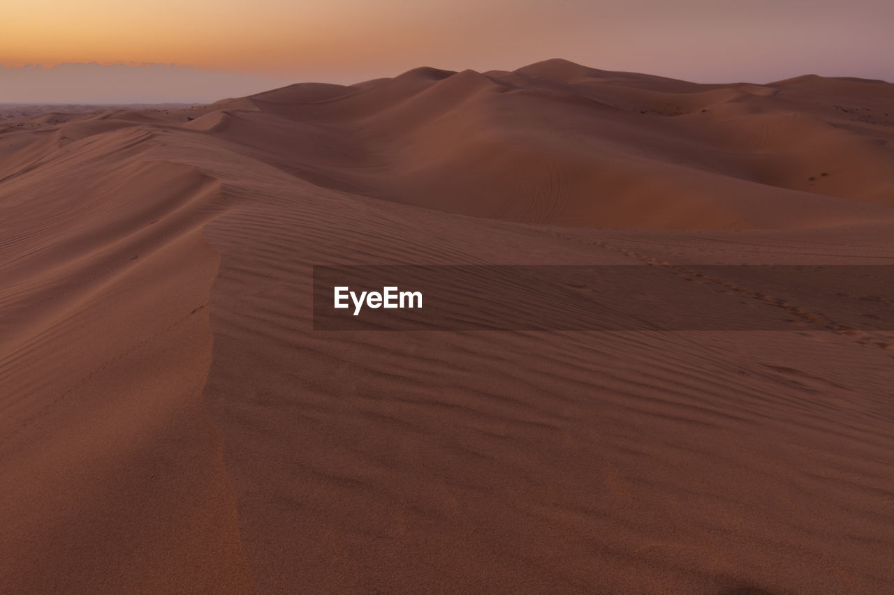 Scenic view of desert against sky during sunset