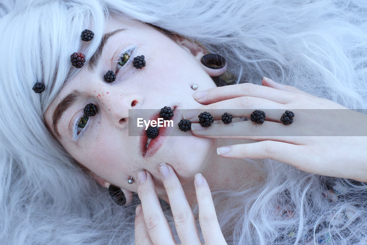 Directly above portrait of female model with blackberries