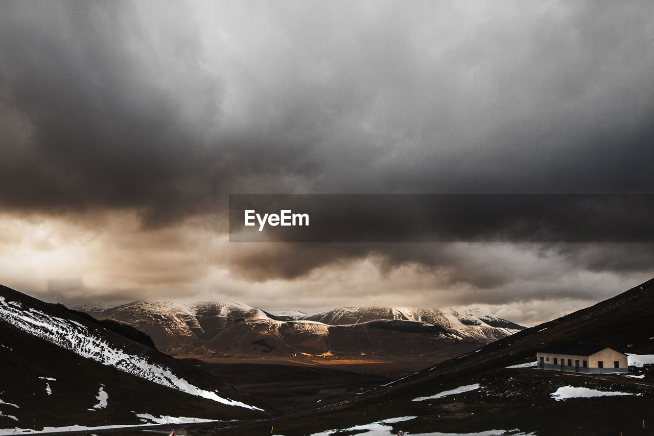 Scenic view of mountains against storm clouds