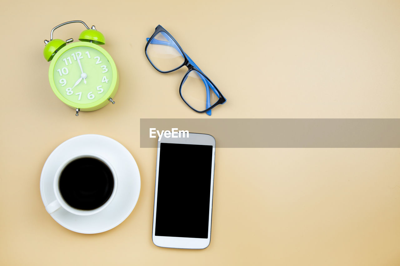 HIGH ANGLE VIEW OF COFFEE CUP ON TABLE AGAINST WHITE BACKGROUND