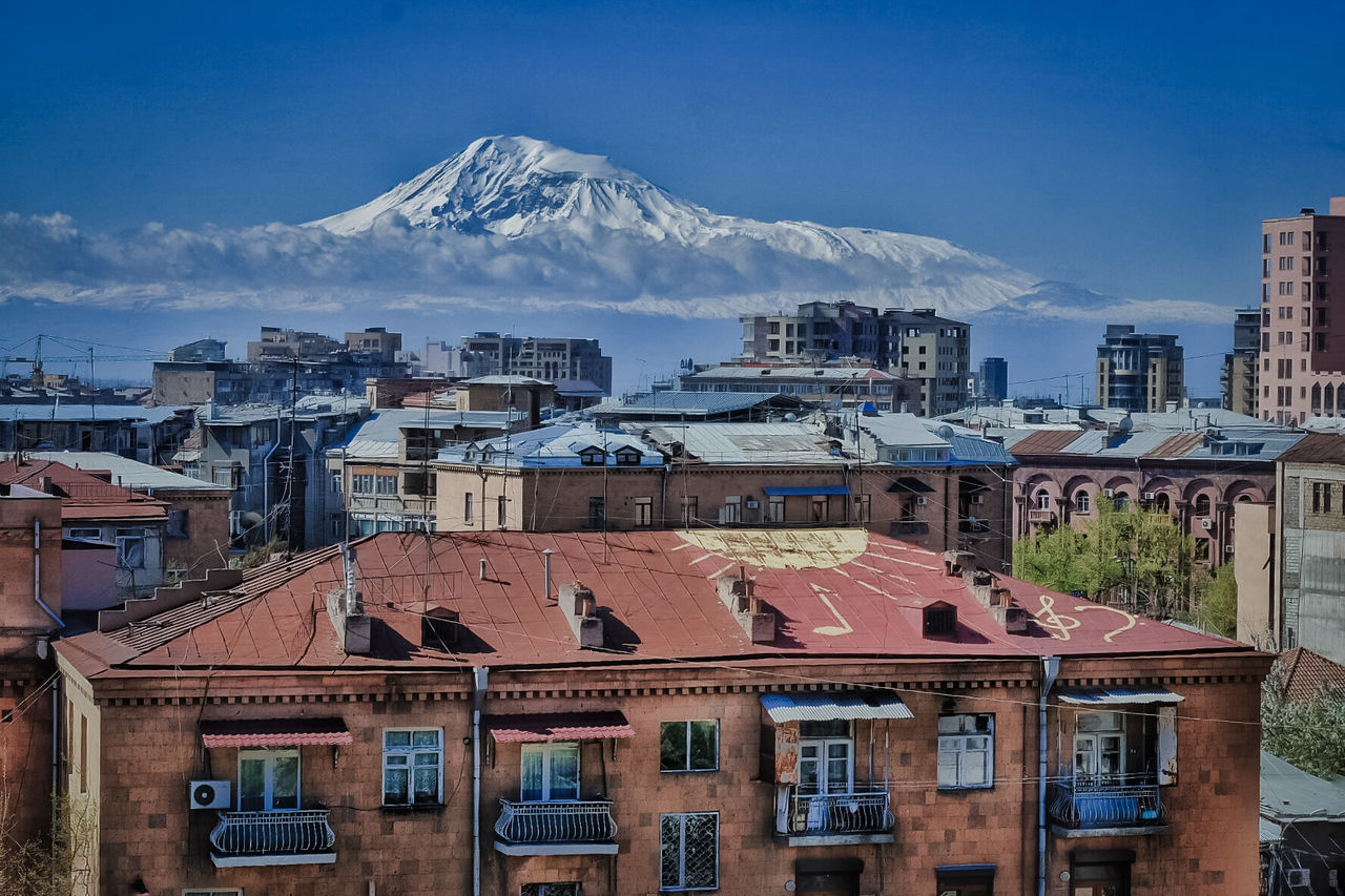 Cityscape against snowcapped mountain