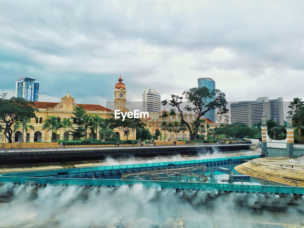 BUILDINGS BY SWIMMING POOL AGAINST SKY