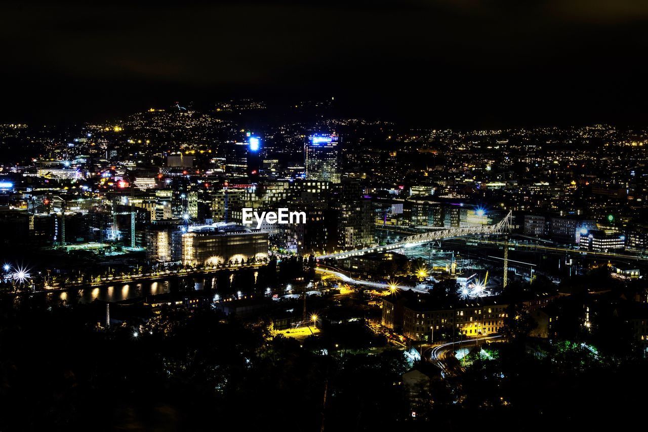 HIGH ANGLE VIEW OF ILLUMINATED BUILDINGS IN CITY