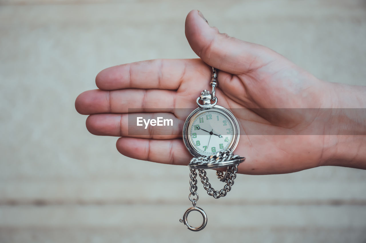 Close-up of hand holding pocket watch