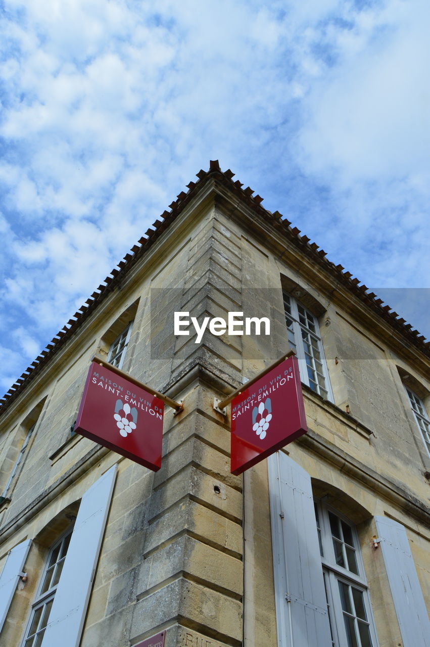 LOW ANGLE VIEW OF ROAD SIGN AGAINST BUILDING