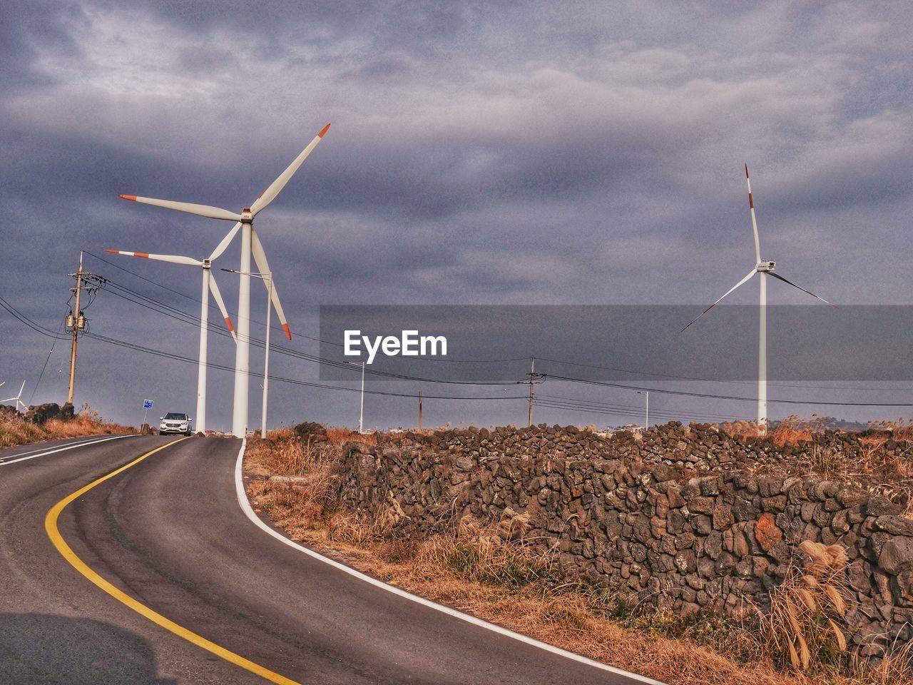 WIND TURBINES ON LANDSCAPE AGAINST SKY