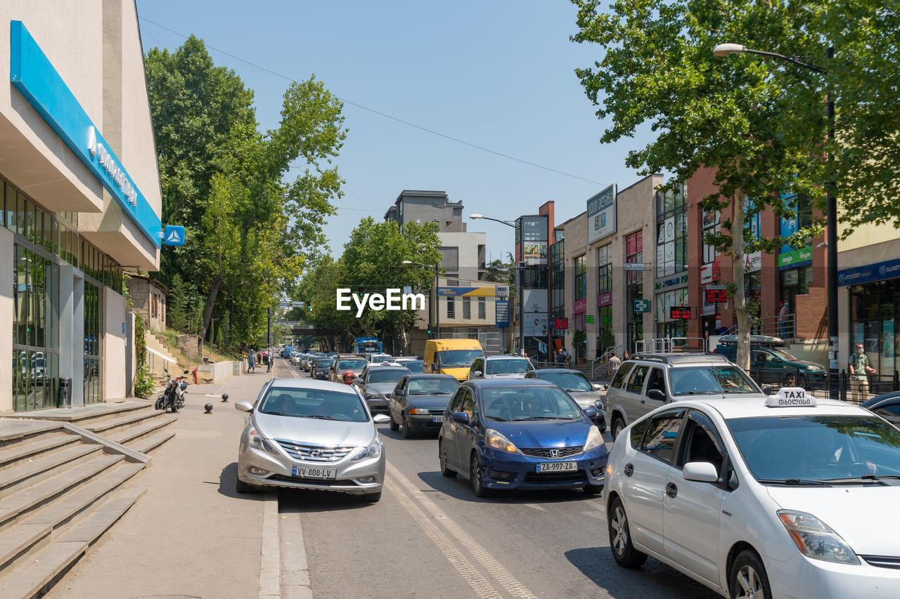 CARS ON STREET BY BUILDINGS IN CITY