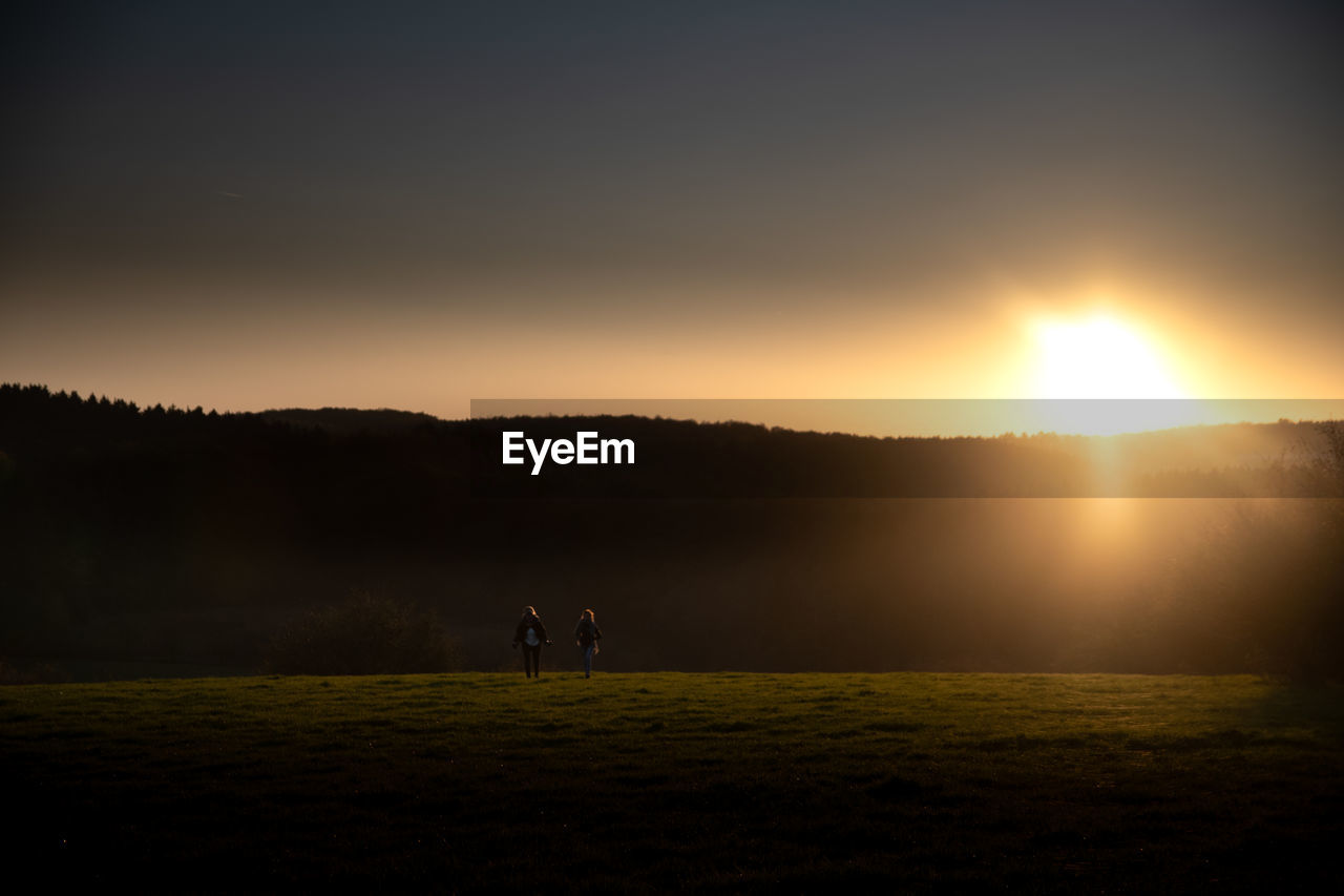 PEOPLE ON FIELD DURING SUNSET