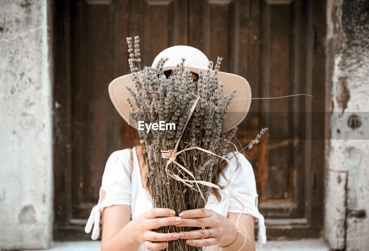 Woman holding dry lavender in front of her face, lifestyle, fashion, portrait.