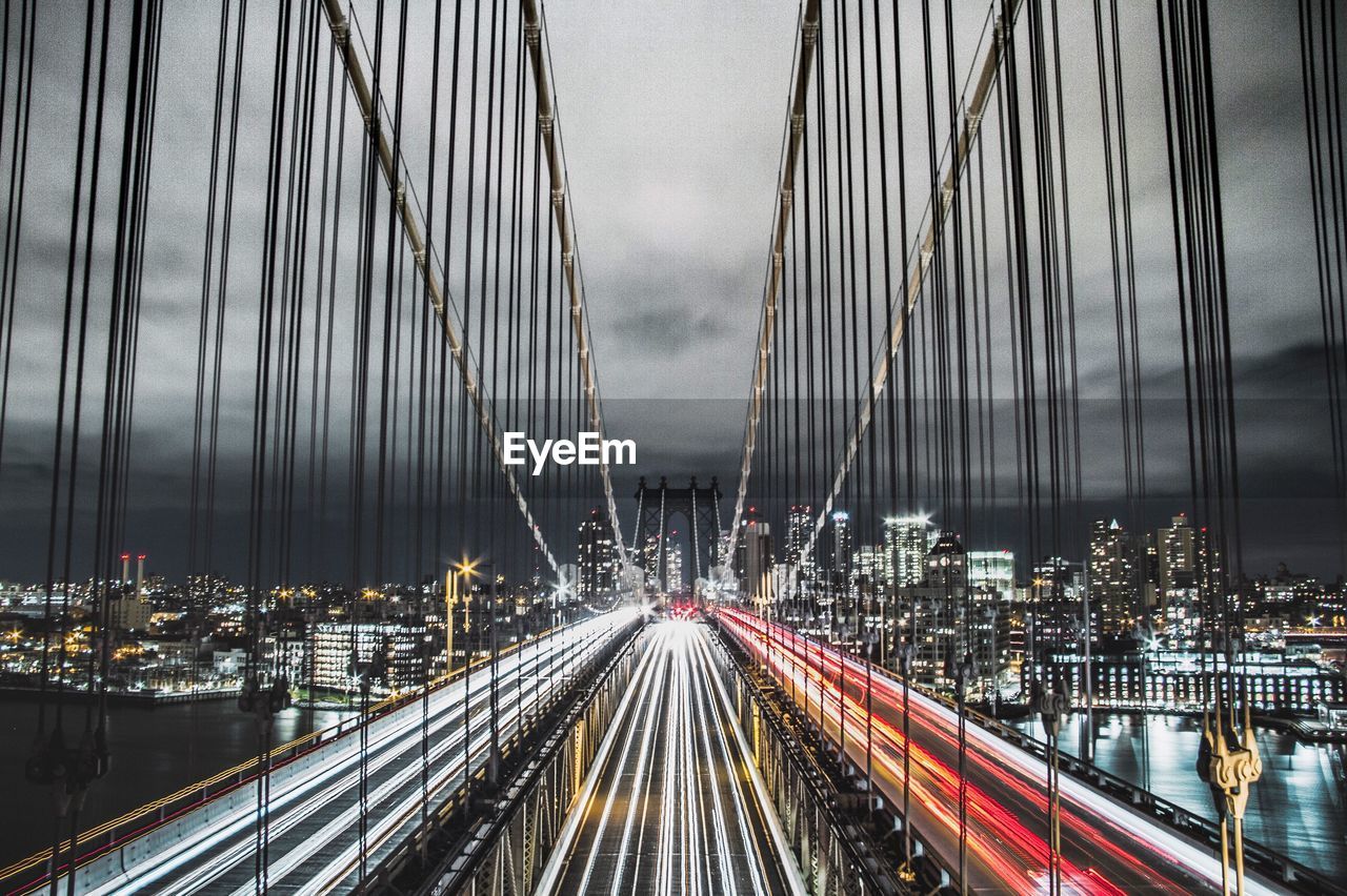 Panoramic view of suspension bridge over city at night