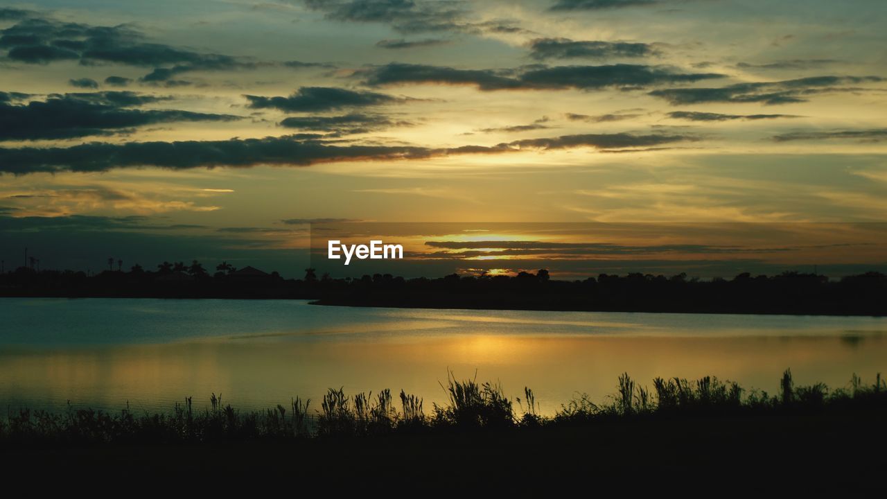 Scenic view of lake against orange sky