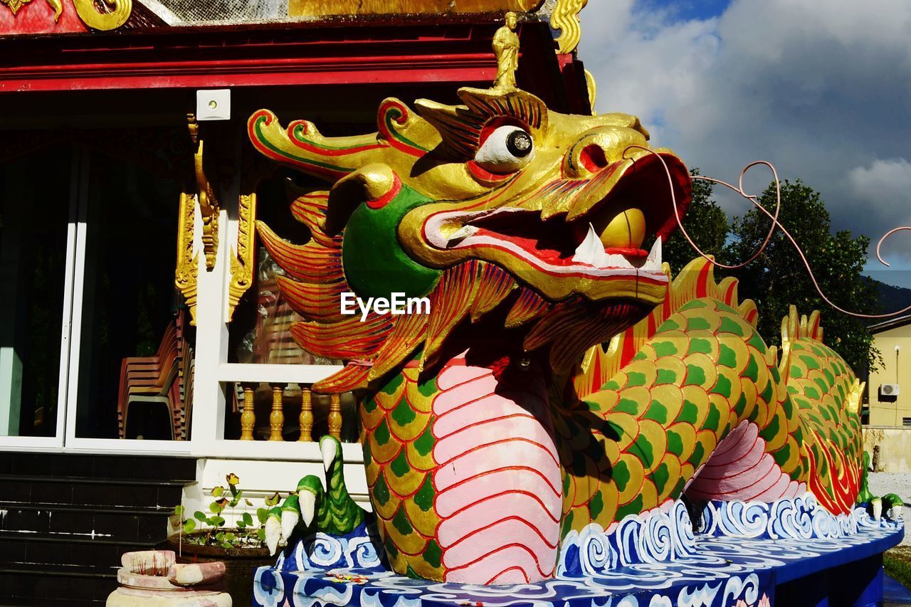 LOW ANGLE VIEW OF BUDDHA STATUE AGAINST TEMPLE