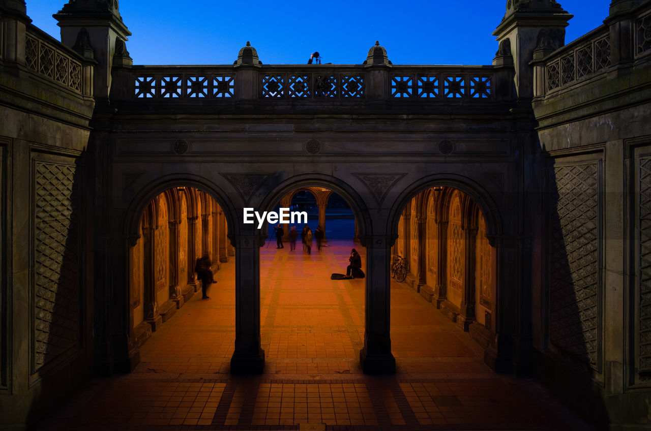 PEOPLE WALKING IN ILLUMINATED BUILDING