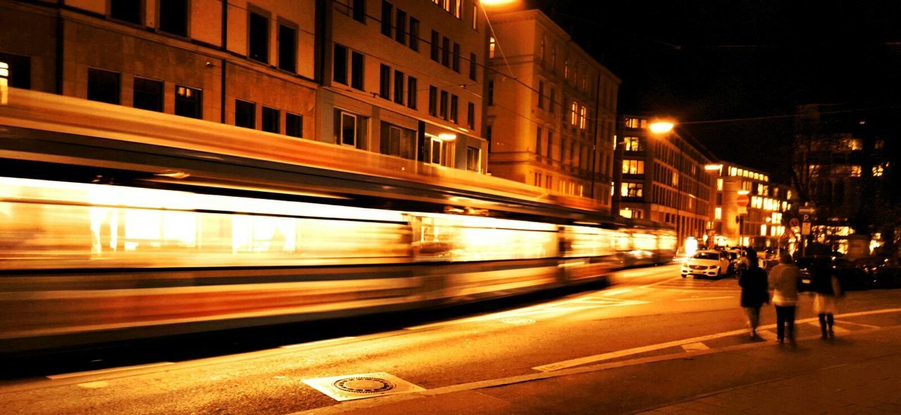 Blurred image of tram moving on illuminated street at night