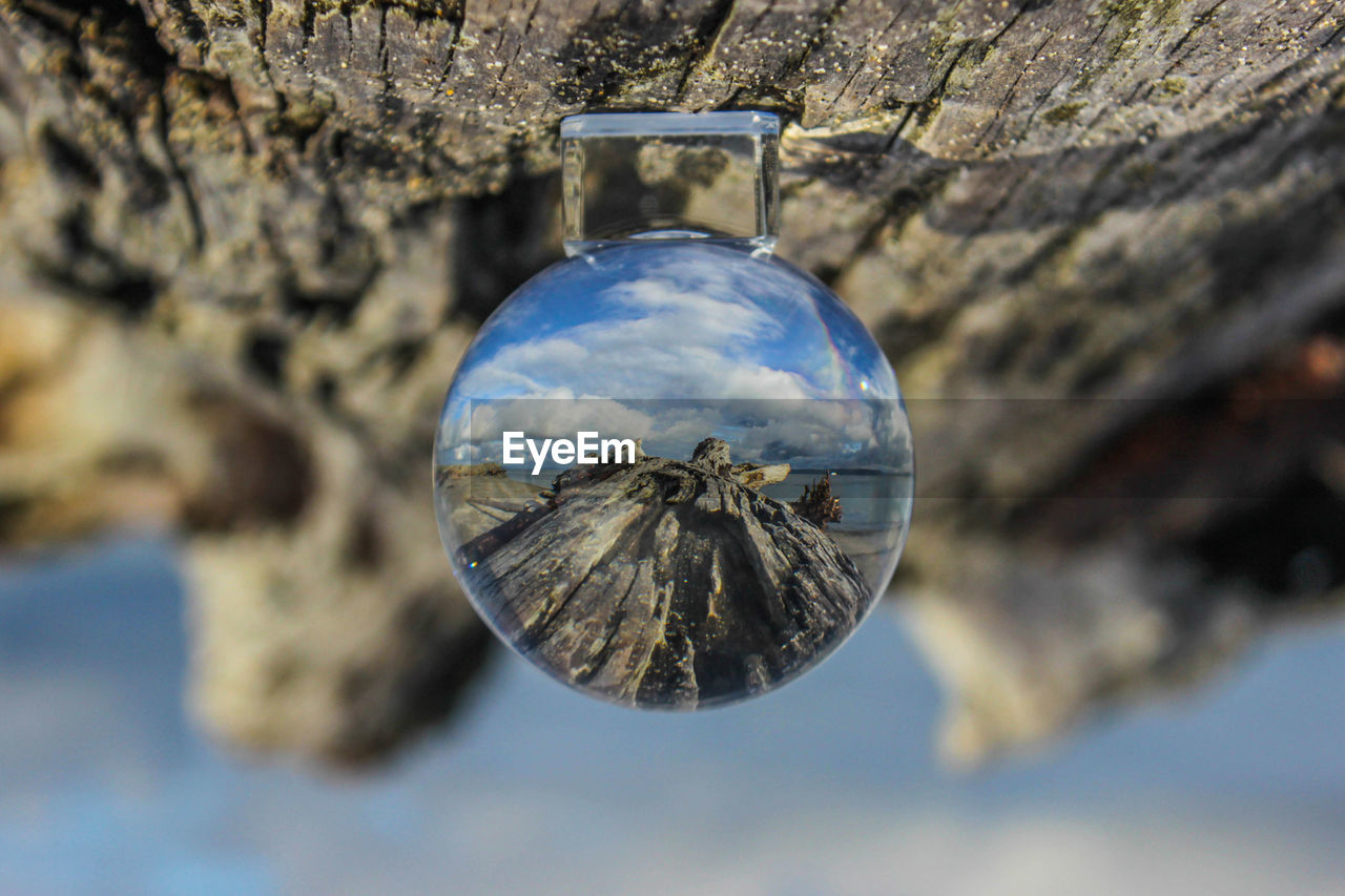 Reflection of sky in crystal ball on wood