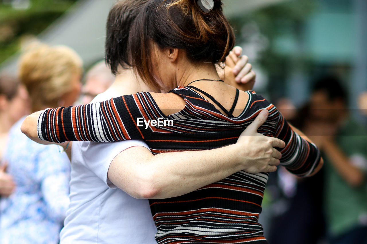 REAR VIEW OF WOMAN LOOKING THROUGH CAMERA