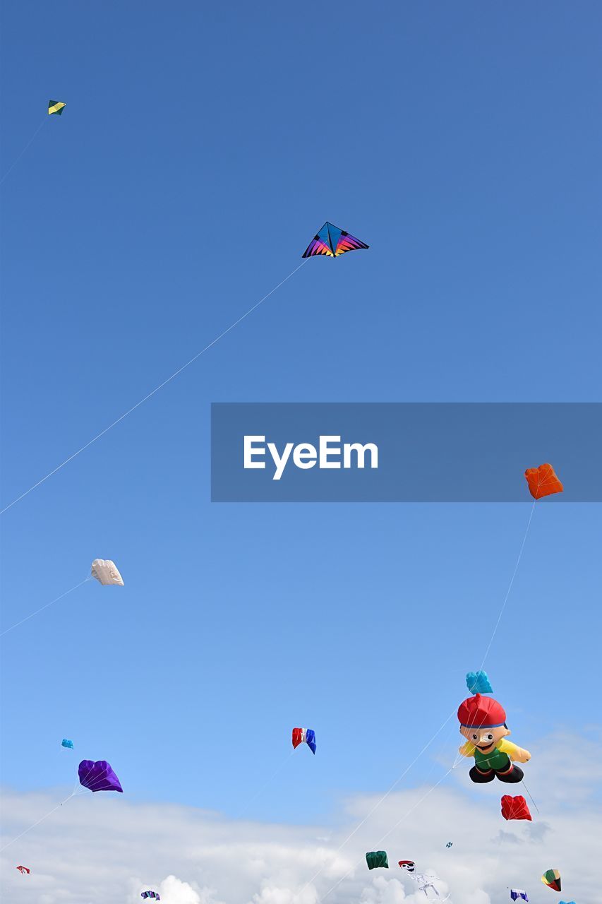 LOW ANGLE VIEW OF KITES FLYING AGAINST SKY