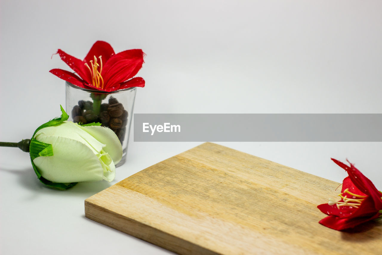 HIGH ANGLE VIEW OF RED FLOWER ON TABLE