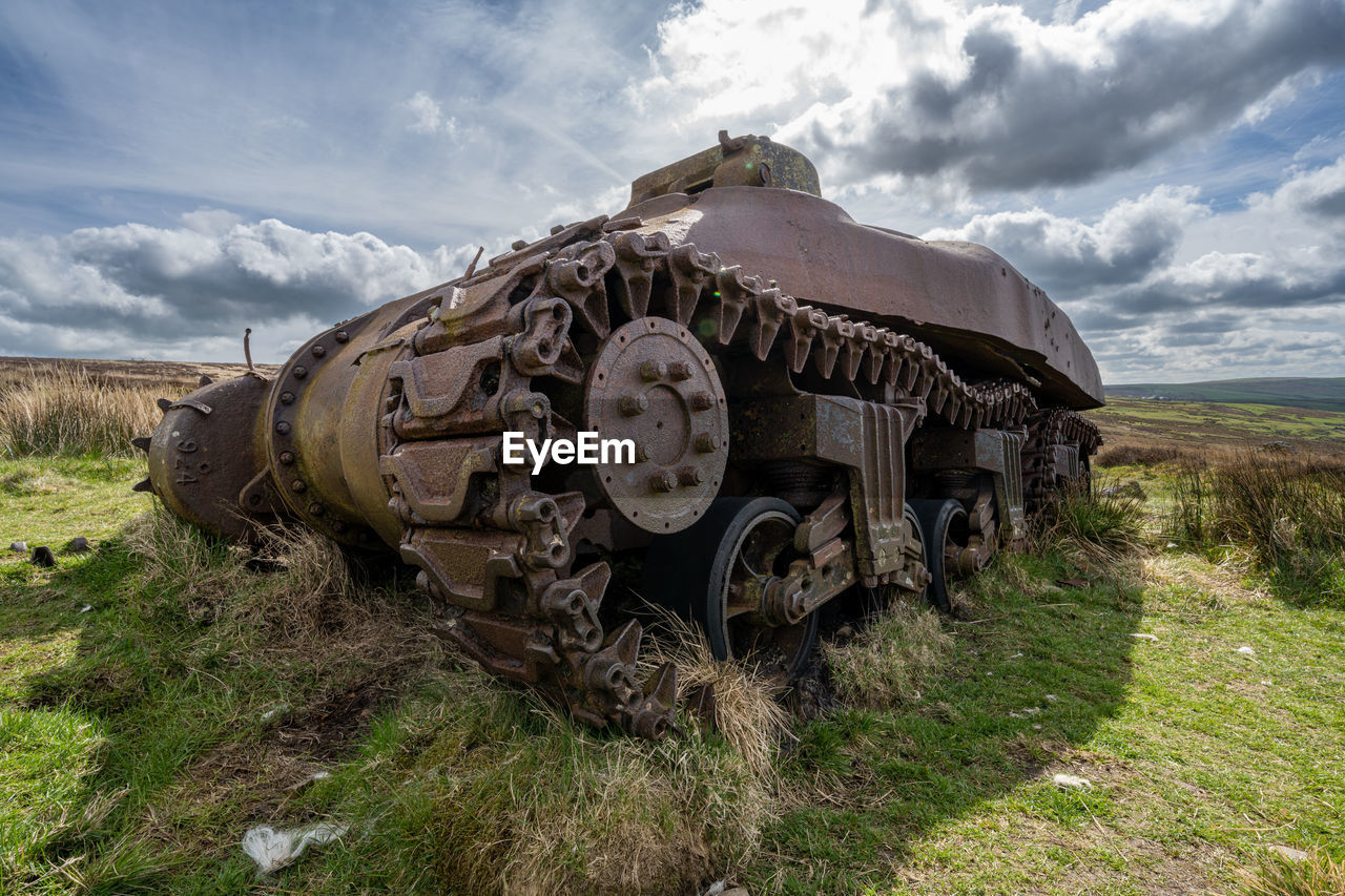 cloud, sky, vehicle, transportation, transport, tank, nature, landscape, mode of transportation, grass, land, abandoned, land vehicle, rural area, off-roading, environment, history, plant, no people, the past, day, old, field, outdoors, metal, combat vehicle, scenics - nature, military, rural scene, travel, non-urban scene, rusty, weapon