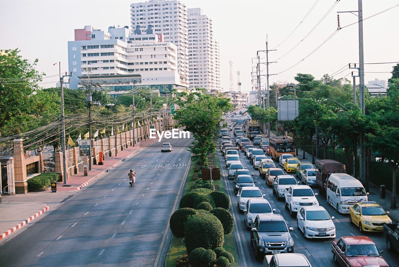 Cars on city street against sky