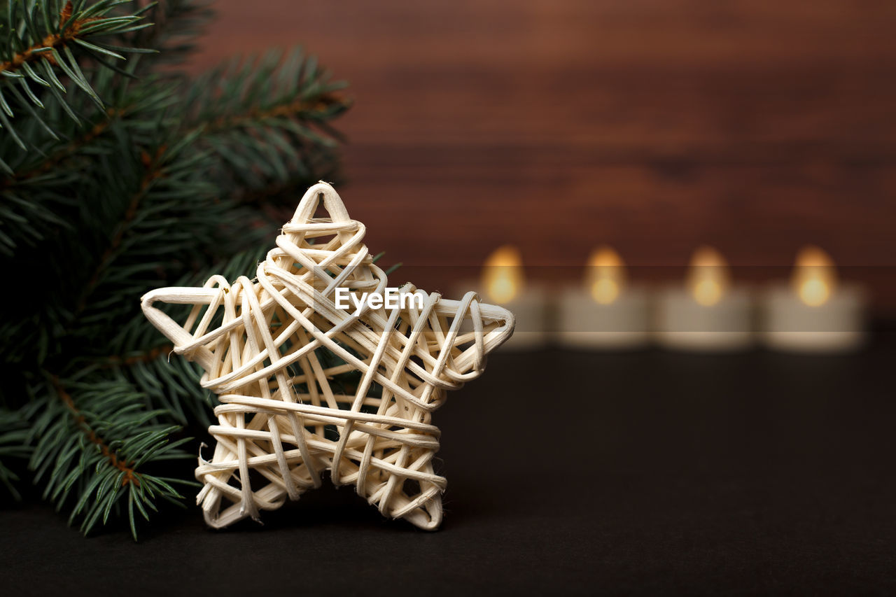 Toy star with christmas tree with candles on a dark wood background