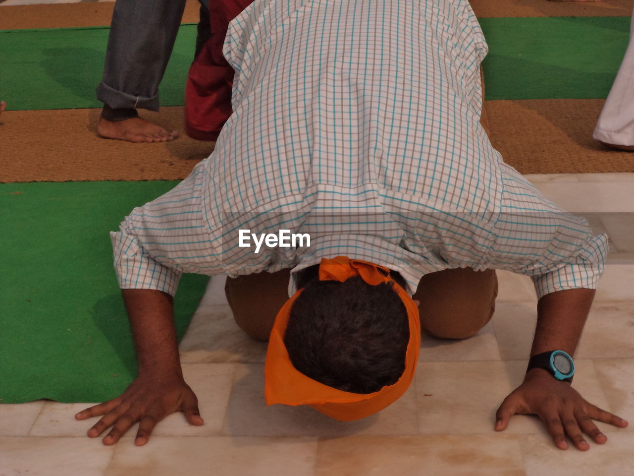 High angle view of man kneeling while praying at gurdwara