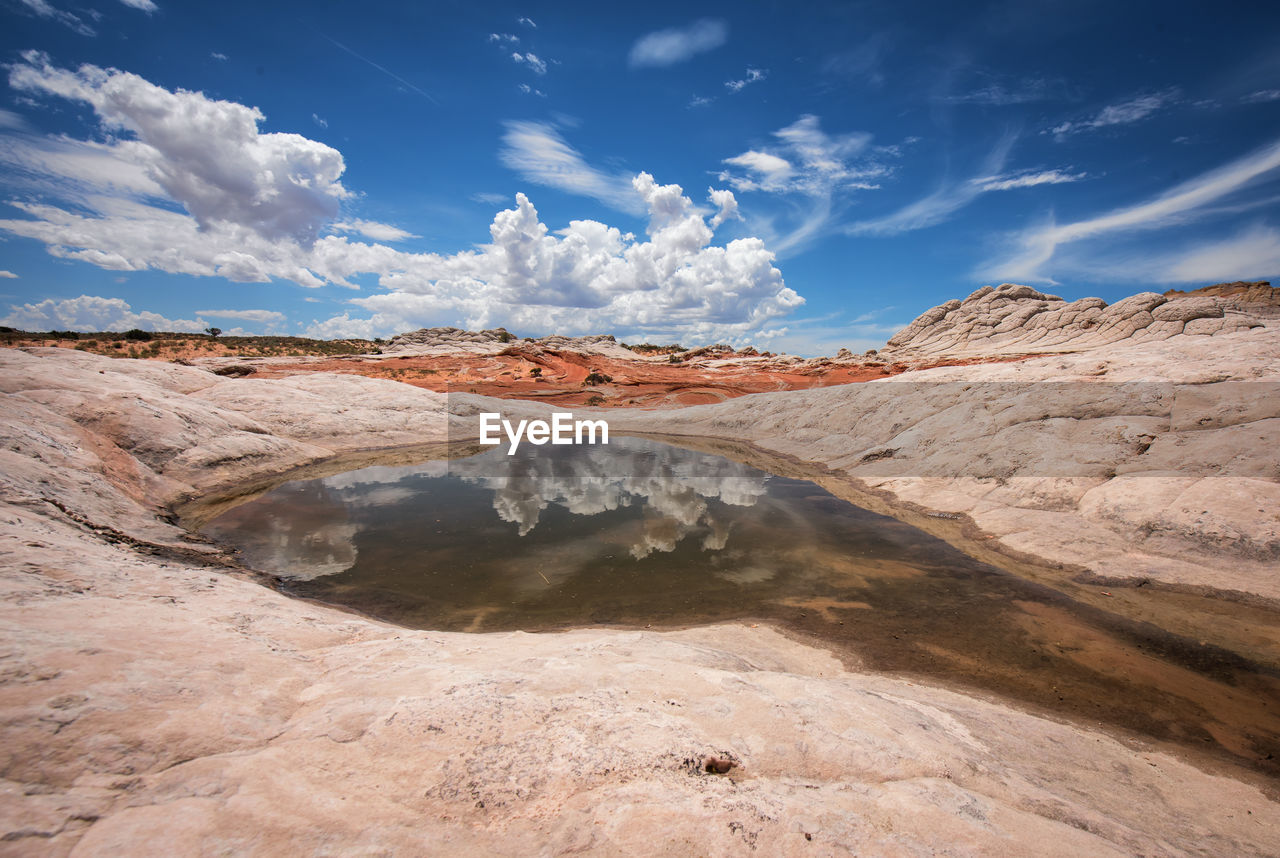 Scenic view of pond amidst rock formations against sky