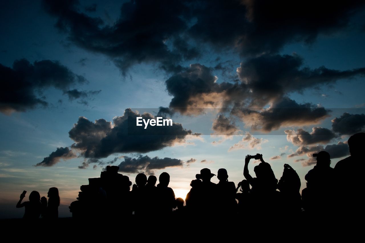 Silhouette people against sky during sunset