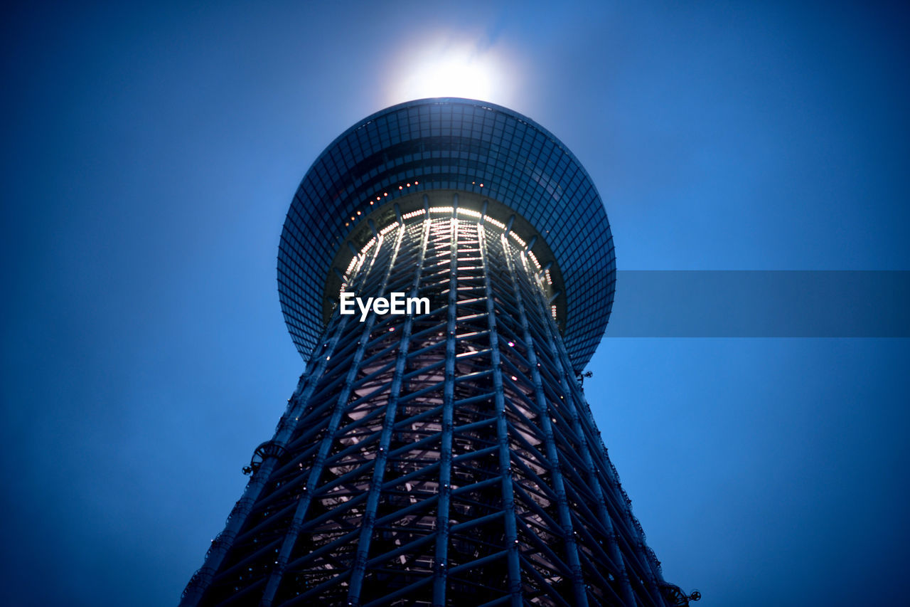 LOW ANGLE VIEW OF ILLUMINATED MODERN BUILDING AGAINST BLUE SKY