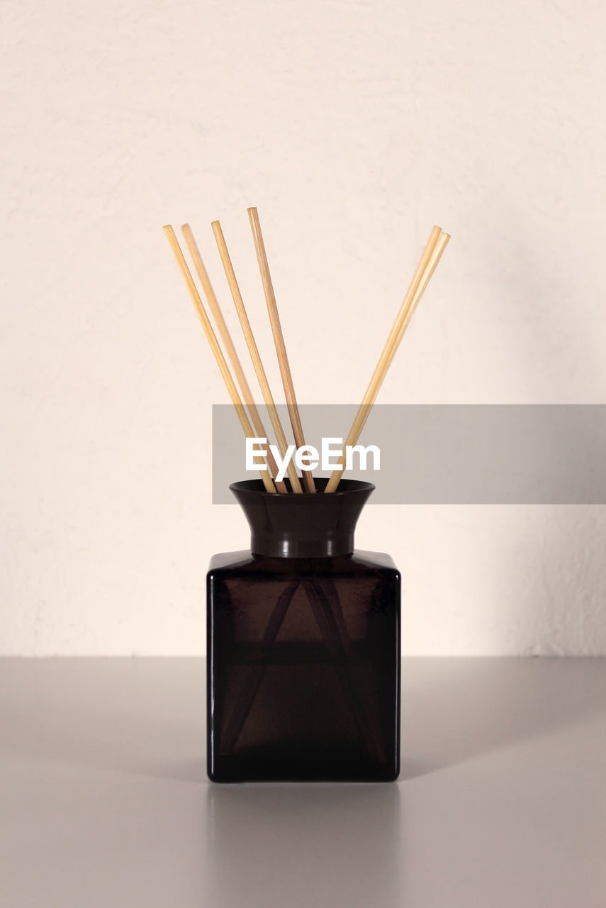 Aroma diffuser with wooden sticks for home on background of white paint wall
