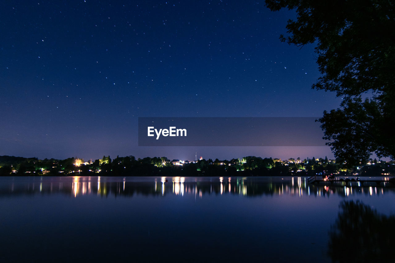 Scenic view of lake against sky at night