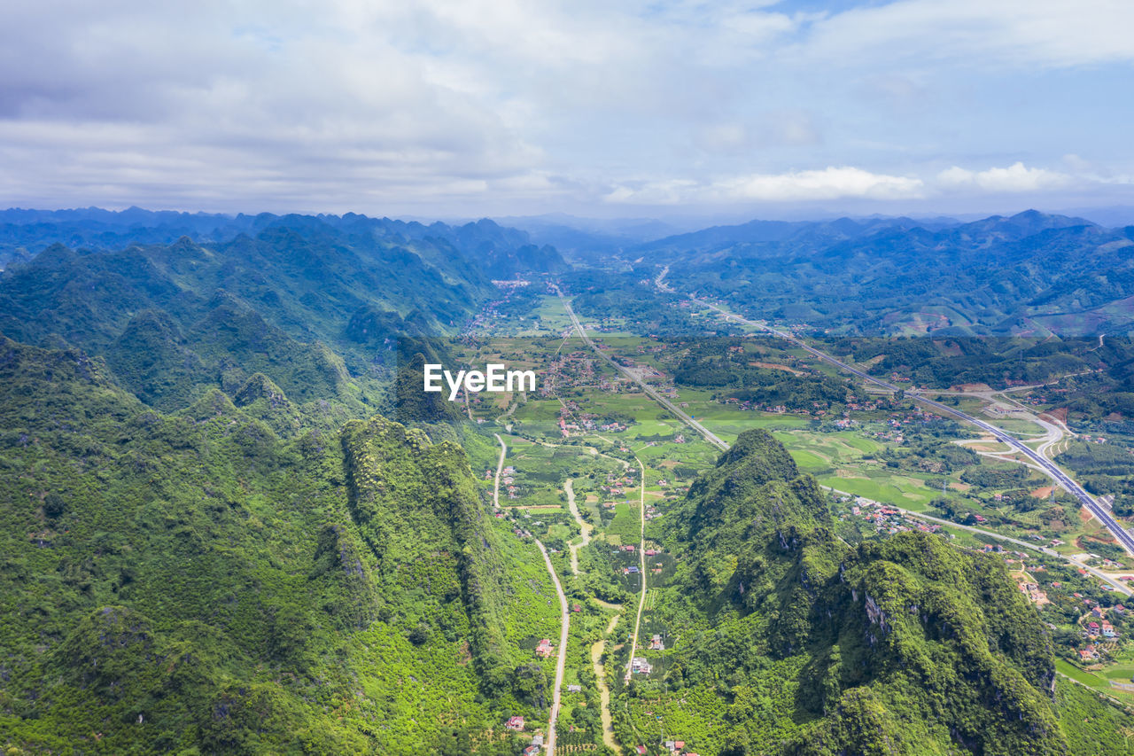 SCENIC VIEW OF TREES AND MOUNTAINS AGAINST SKY