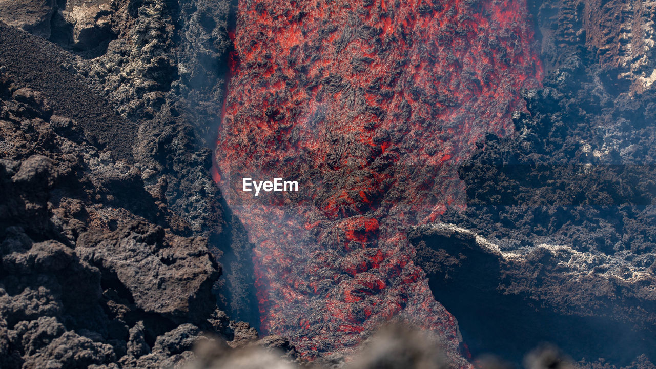 Etna- lava flow detail on volcano  in sicily with smoke and acid vapor